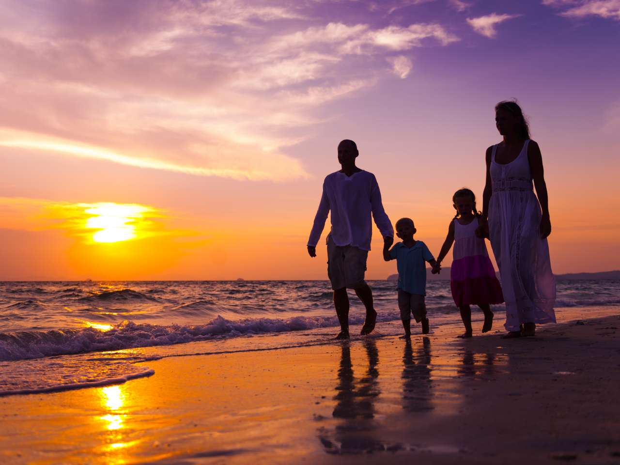 Familie am Strand bei Sonnenuntergang zum Abschluss einer Familienreise Thailand