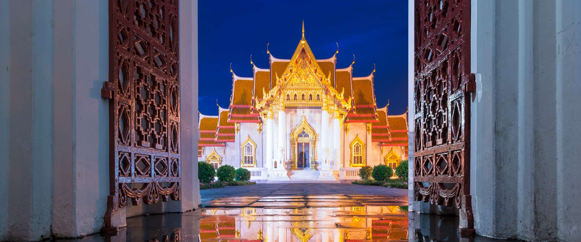 Wat Benchamabophit in Bangkok bei Nacht durch ein geöffnetes Tor