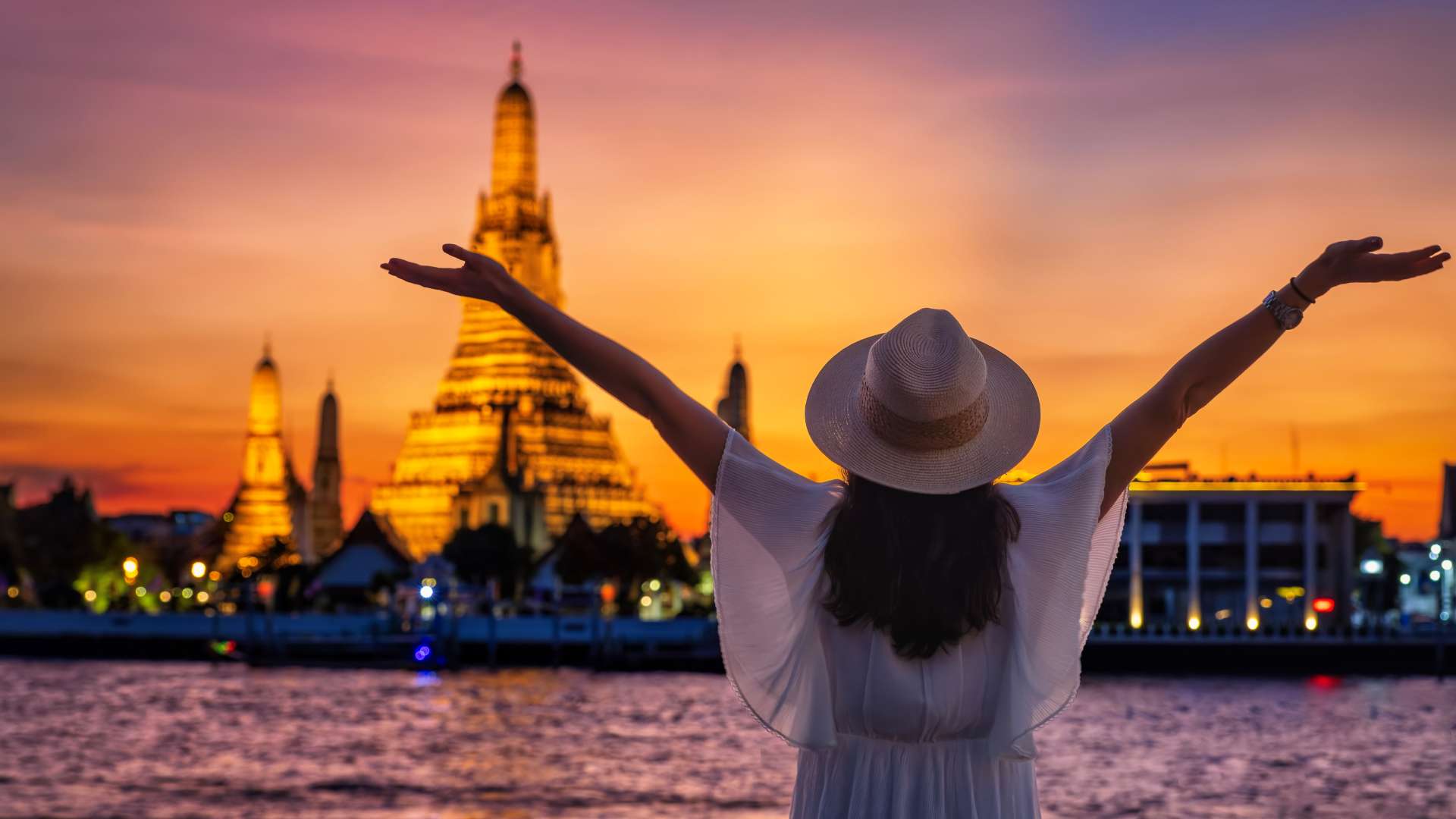 Frau genießt den Sonnenuntergang am Wat Arun in Bangkok zu Beginn einer Thailand Kombireise
