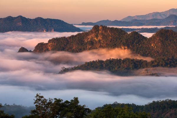 Nebelverhangene Bergketten bei Sonnenaufgang in Westthailand