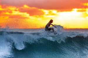 Ein Surfer beim Sonnenuntergang beim Wellenreiten vor Phuket