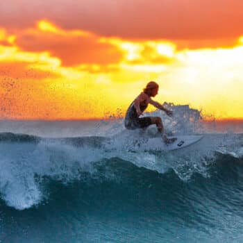 Ein Surfer beim Sonnenuntergang beim Wellenreiten vor Phuket